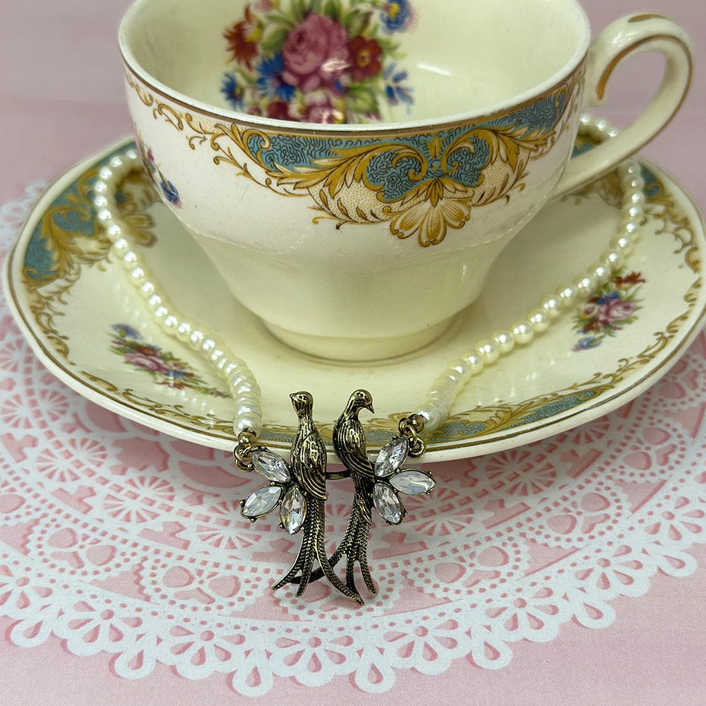 Love Birds Pearl Choker Necklace resting on vintage tea cup